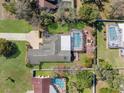 Aerial view of a home with a screened-in pool and a well-manicured lawn, surrounded by mature trees at 8518 Delaware Dr, Weeki Wachee, FL 34607