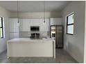 Modern kitchen with white cabinets, marble countertops, stainless steel appliances, and an island at 9 Tee View Rd, Rotonda West, FL 33947