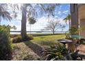 Serene backyard featuring lush green lawn, mature trees, and a peek of the bay at 1111 N Bayshore Blvd # F11, Clearwater, FL 33759