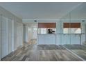 Spacious open-concept living room with wood flooring, a mirrored wall, and breakfast bar at 12055 3Rd E St # 103, Treasure Island, FL 33706