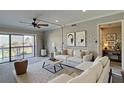Inviting living room with a ceiling fan, sliding glass doors to a balcony, and neutral decor at 12055 3Rd E St # 103, Treasure Island, FL 33706