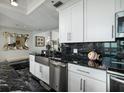 Modern kitchen with stainless steel appliances, black marble counters, and white cabinets offers a sleek design at 1560 Gulf Blvd # 1104, Clearwater Beach, FL 33767