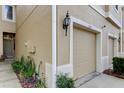 Close-up of a townhome's exterior, highlighting the front door, garage, and well-maintained garden at 2153 Broadway View Ave, Brandon, FL 33510
