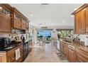 Well-appointed kitchen with granite countertops, wooden cabinetry, and a dining area with water views at 5241 West Shore Dr, New Port Richey, FL 34652