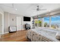 Serene main bedroom with hardwood floors, balcony access, and water views at 5241 West Shore Dr, New Port Richey, FL 34652