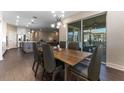 Open-concept dining area with modern chandelier, wood table and chairs, and sliding glass doors to patio at 7096 Heron Walk Ln, Wesley Chapel, FL 33545