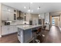Modern kitchen featuring white cabinets, stainless steel appliances, and a large island with seating at 7096 Heron Walk Ln, Wesley Chapel, FL 33545