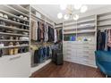 Spacious walk-in closet with custom shelving, drawers, and hanging rods for optimal storage at 7096 Heron Walk Ln, Wesley Chapel, FL 33545
