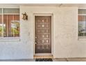 Charming covered front door with decorative sconce lighting and a textured stucco wall at 1001 Pearce Dr # 106, Clearwater, FL 33764
