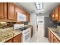 Bright kitchen featuring granite countertops, stylish backsplash, gas range, and stainless steel refrigerator at 10038 62Nd N Ter # 1, St Petersburg, FL 33708