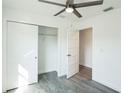 Bright bedroom with modern ceiling fan, and spacious closet, complemented by stylish wood-look flooring at 114 25Th E St, Palmetto, FL 34221