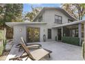 Private backyard patio with lounge chairs, screened porch, and lush greenery at 206 W Minnehaha St, Tampa, FL 33604