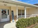Inviting front porch adorned with decorative wreath and 'Welcome' sign, complemented by well-trimmed shrubbery at 22941 Leafwood Ct, Land O Lakes, FL 34639