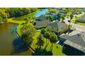 Aerial view of a neighborhood featuring homes with backyard lake access, lush greenery and blue skies at 2734 Silvermoss Dr, Wesley Chapel, FL 33544