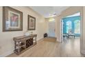 Bright foyer with a decorative table, elegant artwork, and wood-look flooring leading to various rooms at 2734 Silvermoss Dr, Wesley Chapel, FL 33544