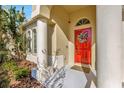 Inviting front entrance with a bright red door, decorative wreath, and meticulously landscaped surroundings at 2734 Silvermoss Dr, Wesley Chapel, FL 33544