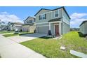 Well-maintained two-story home showcasing a lush green lawn, attached garage, and a welcoming entrance at 35542 Buttonweed, Zephyrhills, FL 33541