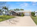 This charming single-Gathering home features a well-manicured lawn, a stone accent wall, and neutral paint at 3639 Richboro Dr, Holiday, FL 34691