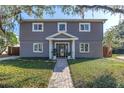 Charming two-story home with gray siding and brick accents, complemented by a lush green lawn and inviting walkway at 4514 W Beachway Dr, Tampa, FL 33609
