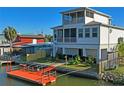 The backyard showcases a private dock, fenced yard, and an outdoor spiral staircase leading to a screened balcony at 5100 Cedarbrook, Hernando Beach, FL 34607