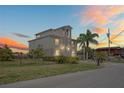 A beautifully designed house with palm trees, a driveway, and a manicured lawn during a colorful sunset at 5100 Cedarbrook, Hernando Beach, FL 34607
