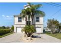 The home features a two-car garage and a well-manicured front yard with rock landscaping and palm trees at 5100 Cedarbrook, Hernando Beach, FL 34607