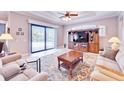 Bright living room with a large window overlooking the pool and a decorative wooden entertainment center at 5115 Abisher Wood Ln, Brandon, FL 33511