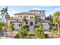 Stunning Mediterranean-style home with a tile roof, lush landscaping, and a gated entrance at 5128 W Longfellow Ave, Tampa, FL 33629