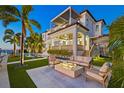Inviting outdoor space with a modern fireplace, comfortable seating, and a private pool with waterfront views at 5128 W Longfellow Ave, Tampa, FL 33629