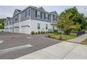 Townhouse exterior featuring a garage, sidewalk, and manicured landscaping at 6615 S Manhattan Ave # 2, Tampa, FL 33616