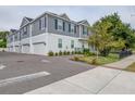 Gray two-story townhome featuring an attached garage and a fenced yard at 6615 S Manhattan Ave # 2, Tampa, FL 33616