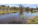 Scenic pond view with lily pads and wooden fence surrounding the property on a sunny day at 7843 Shoupe Rd, Plant City, FL 33565