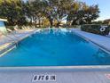 Large community pool for residents, surrounded by seating and lush landscaping at 811 Helmsman Way, Palm Harbor, FL 34685