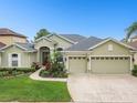 Attractive home with a well-maintained yard, mature landscaping, and an attached three-car garage at 1204 Blackrush Dr, Tarpon Springs, FL 34689