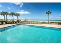 Refreshing pool area with lounge chairs overlooking the serene ocean view at 1460 Gulf Blvd # 506, Clearwater Beach, FL 33767