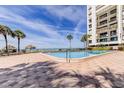 Beautiful beachfront pool with palm trees and tiki huts for shade on a sunny day at 1460 Gulf Blvd # 506, Clearwater Beach, FL 33767