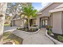 Home featuring a brick facade, manicured landscaping, and a double door entrance to the residence at 1708 Country Trails Dr, Safety Harbor, FL 34695