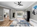 Bright living room featuring wood floors, neutral paint, and a view of the outdoor pool and patio at 1708 Country Trails Dr, Safety Harbor, FL 34695