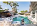 Backyard oasis featuring a luxurious pool with water features and inviting cabana seating areas at 1772 Indian Rocks S Rd, Largo, FL 33774