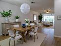 Bright dining room with hardwood floors, modern furniture, and an elegant hanging light fixture at 2297 Lark E Cir # E, Palm Harbor, FL 34684