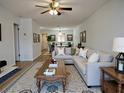 Open-concept living room featuring a comfortable sectional sofa, ceiling fan and views into the dining room at 2297 Lark E Cir # E, Palm Harbor, FL 34684