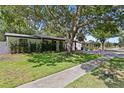 Charming single-story home with lush landscaping and a welcoming front entrance and covered parking at 2912 W Winthrop Rd, Tampa, FL 33611