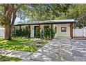 Charming single-story home with lush landscaping and a welcoming front entrance and covered parking at 2912 W Winthrop Rd, Tampa, FL 33611