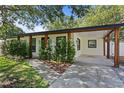 Charming single-story home with lush landscaping and a welcoming front entrance and covered parking at 2912 W Winthrop Rd, Tampa, FL 33611