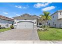 Attractive single-Gathering home featuring a brick driveway, stone accents, and lush landscaping at 31046 Lindentree Dr, Wesley Chapel, FL 33543