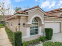 Beautiful home exterior with a well-manicured lawn, arched window, and a two-car garage at 3876 Timber Ridge Ct, Palm Harbor, FL 34685