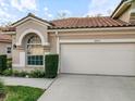 Front view of a home featuring a two-car garage and manicured landscaping at 3876 Timber Ridge Ct, Palm Harbor, FL 34685