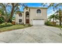 Inviting home with a two-car garage, manicured lawn, and an arched entryway creating a warm welcome at 407 S West Shore Blvd, Tampa, FL 33609