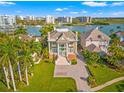 Beautiful waterfront home with lush landscaping, a circular driveway, and stunning curb appeal at 436 St Andrews Dr, Belleair, FL 33756