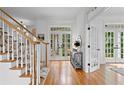 Inviting hallway with hardwood floors, French doors leading to the backyard, and staircase with a patterned runner at 4502 W Culbreath Ave, Tampa, FL 33609